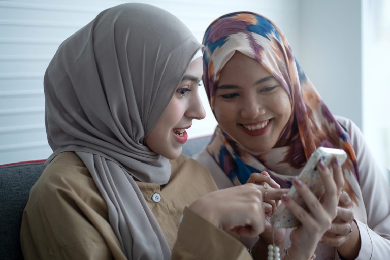 Young women looking at a phone and laughing.
